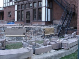 Commercial masonry contractors restoring stone entryway.