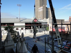 Commercial masonry contractors lifting a stone sculpture